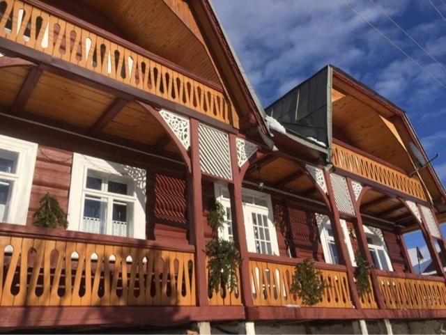 a large wooden building with a balcony on it at DomPodNiebem in Ždiar