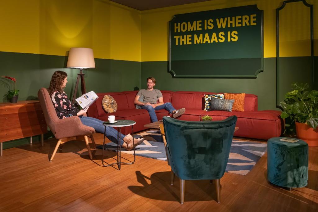 dwoje ludzi siedzących na kanapie w salonie w obiekcie Stayokay Hostel Maastricht w mieście Maastricht