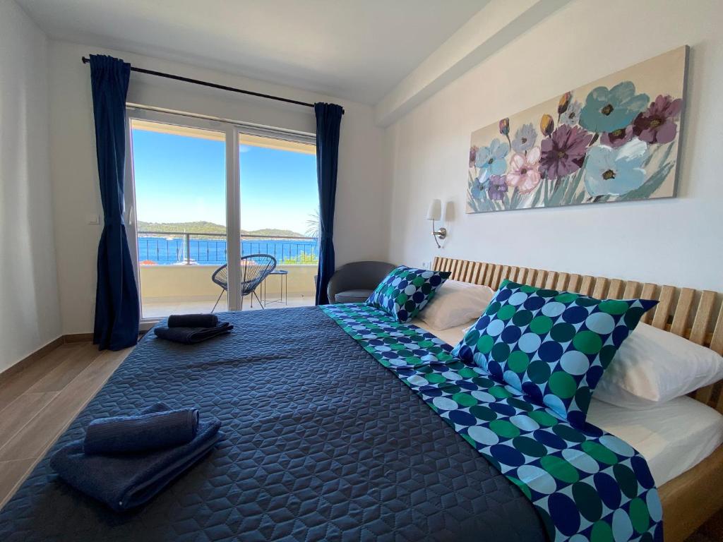 a bedroom with a bed and a large window at Apartment Sandra (2+2) with a breathtaking view 2 in Vis