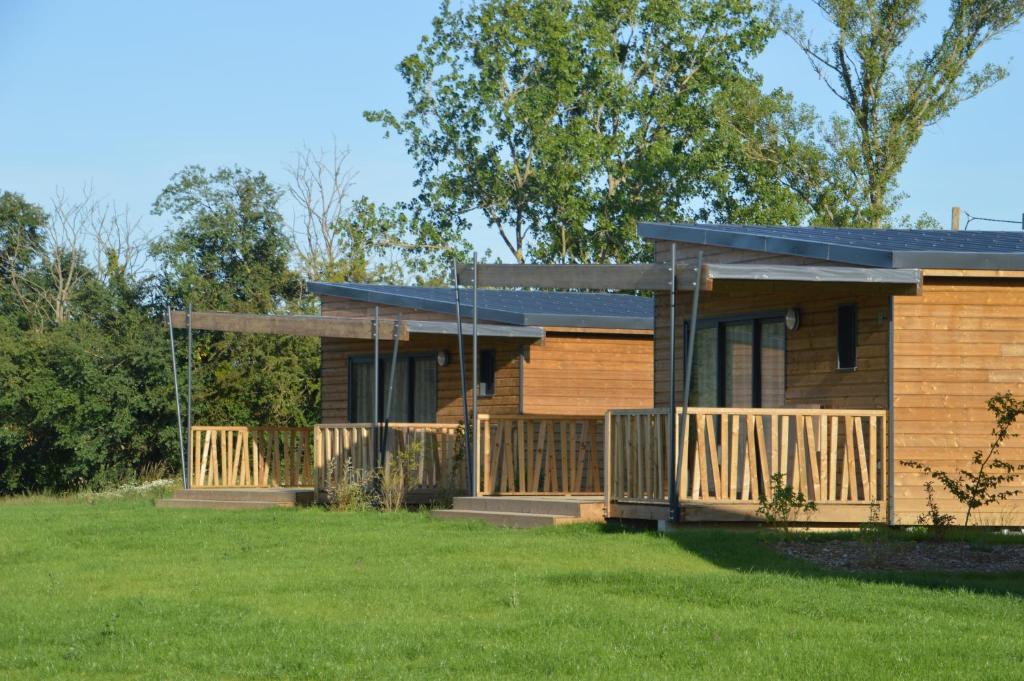 ein Blockhaus mit einer Veranda und einem Hof in der Unterkunft Cottages du Golf Fleuray-Amboise in Cangey