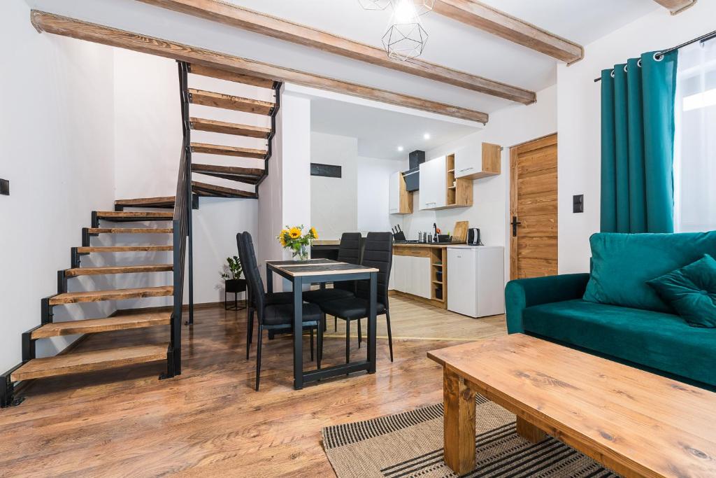 uma sala de estar com um sofá verde e uma mesa em Malinowy Chruśniak Apartamenty em Hoczew