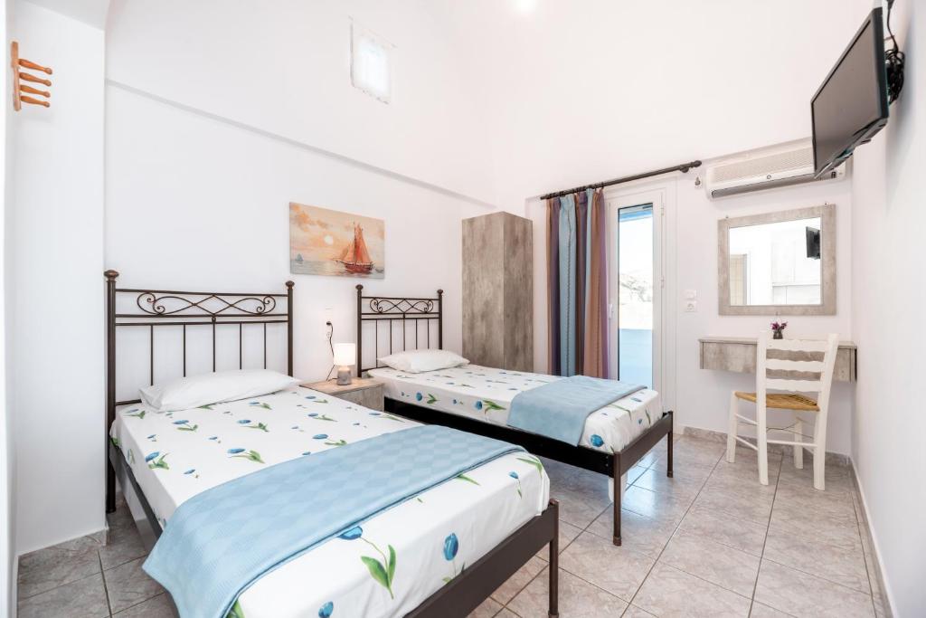 a bedroom with two beds and a tv in it at Panorama Rooms in Anafi