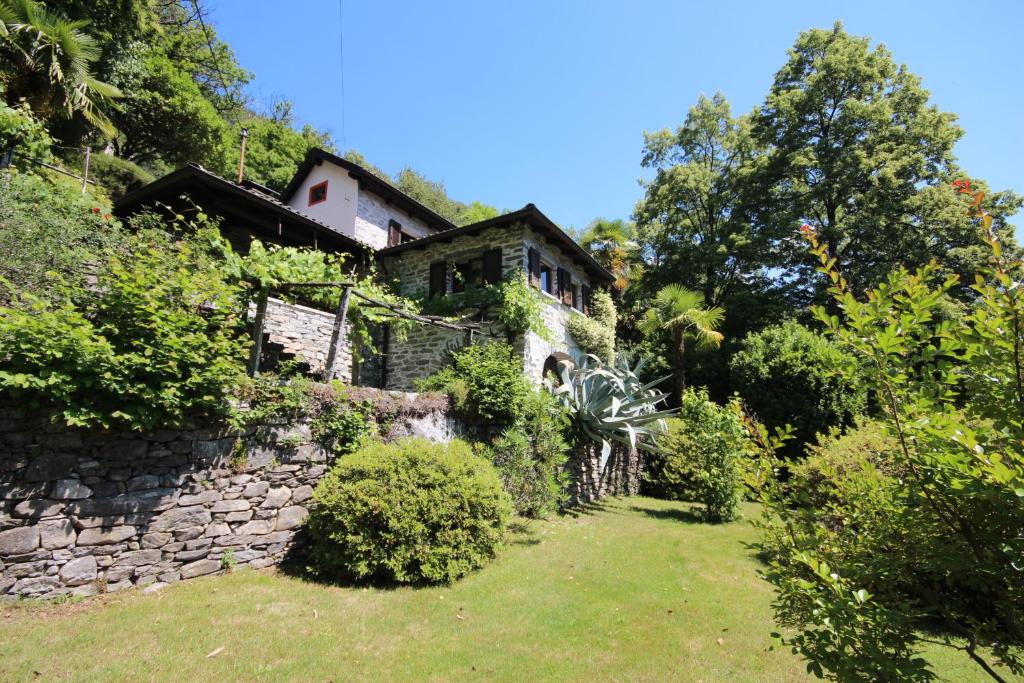 ein altes Steinhaus mit einer Steinmauer in der Unterkunft Casa Ilvea in Cavigliano