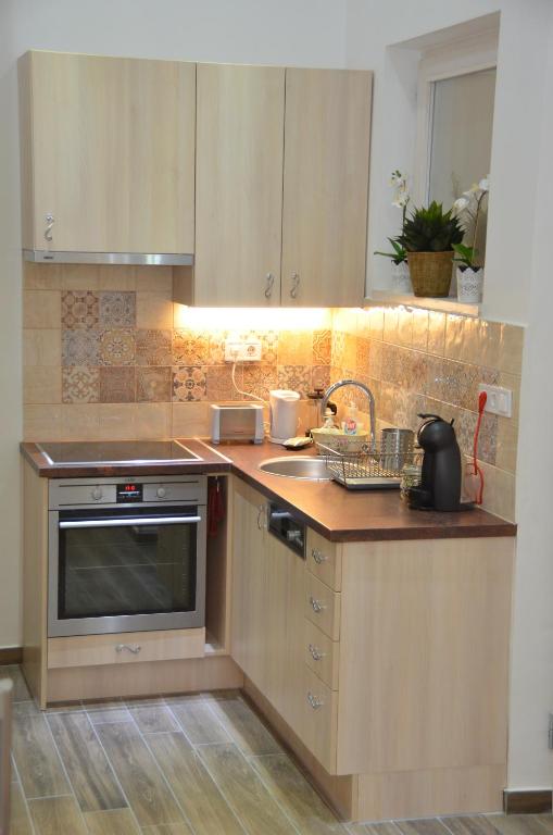 uma cozinha com um lavatório e um fogão forno superior em NN Apartmanette em Budapeste