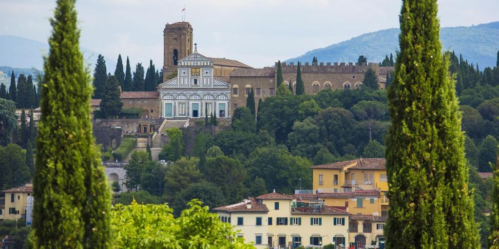 een groot gebouw op een heuvel met bomen bij A Postcard View in a Vintage Apartment in Florence