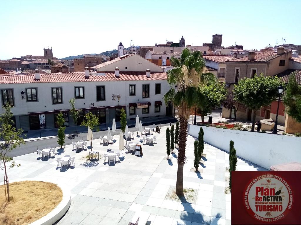 Habitación con vistas a un patio con sillas y árboles. en Apartamentos Turísticos La Garza, en Cáceres