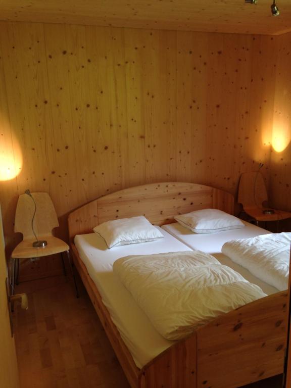 2 camas individuais num quarto com paredes de madeira em 2-Zimmer Ferienwohnung,Parterre,Sitzplatz,Garage em Adelboden