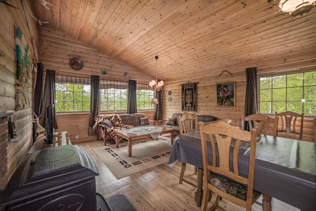 a log cabin with a dining room and living room at Bungalow in Sirdal in Tjørhom