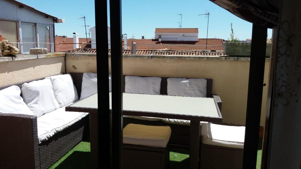 balkon z białymi poduszkami na dachu budynku w obiekcie Apartamento vistas catedral w mieście León