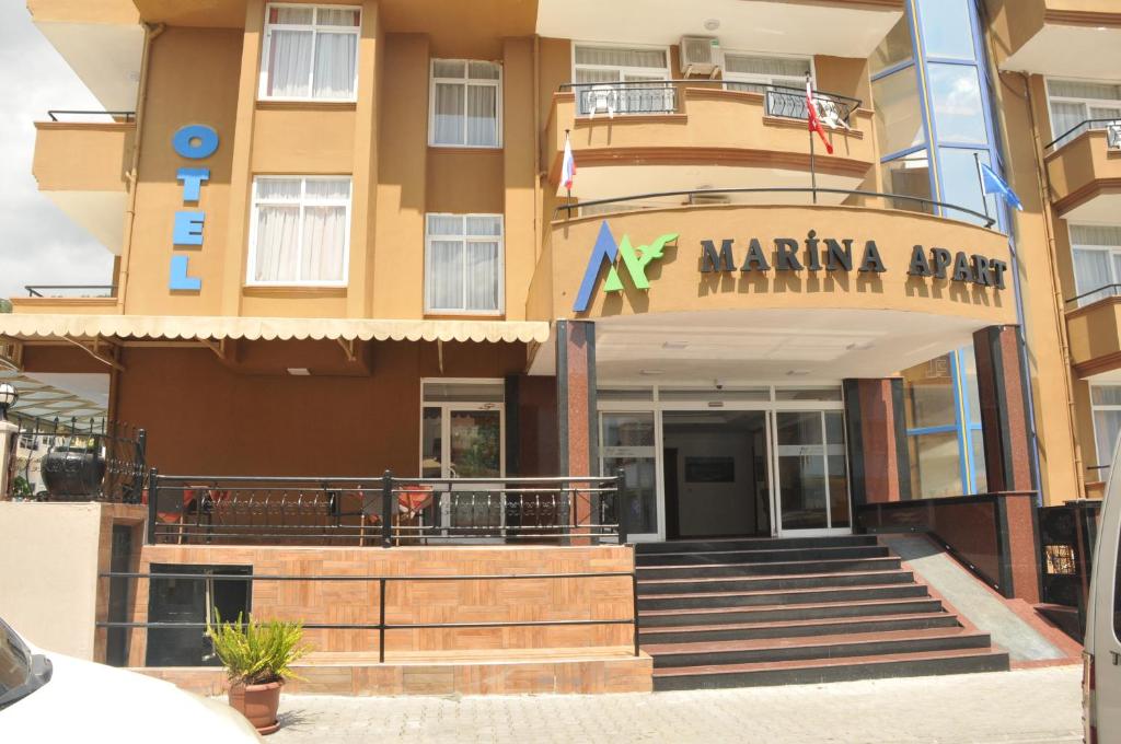 un edificio de apartamentos en el puerto deportivo con un cartel en Marina Apart Hotel, en Marmaris