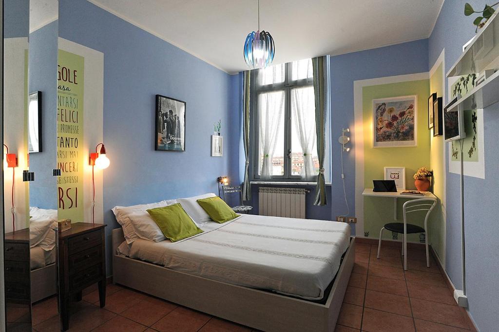 una camera da letto con pareti blu e un letto con cuscini verdi di Uno sguardo su Porta Palazzo by Wonderful Italy a Torino