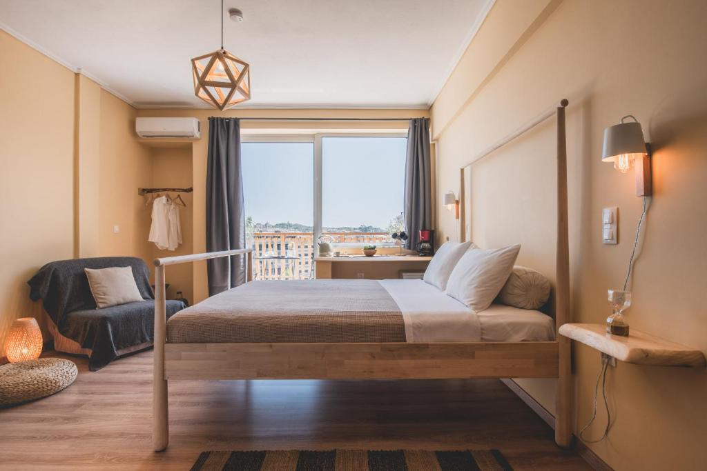 a bedroom with a bed and a window and a chair at Acropolis View - Living Stone Sapphire Apartment in Athens