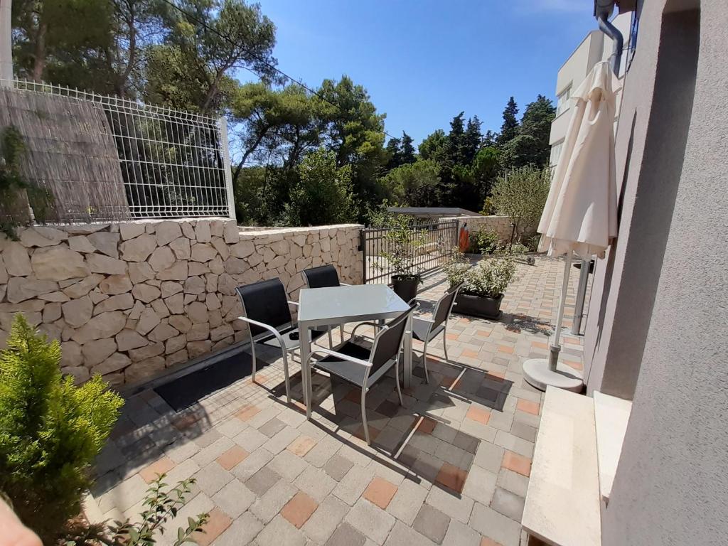 een patio met een tafel en stoelen en een stenen muur bij Holiday Home Don in Zadar