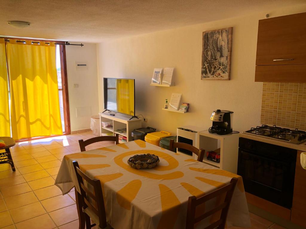 sala de estar con mesa y cocina en Sole Comino, en Santa Lucia