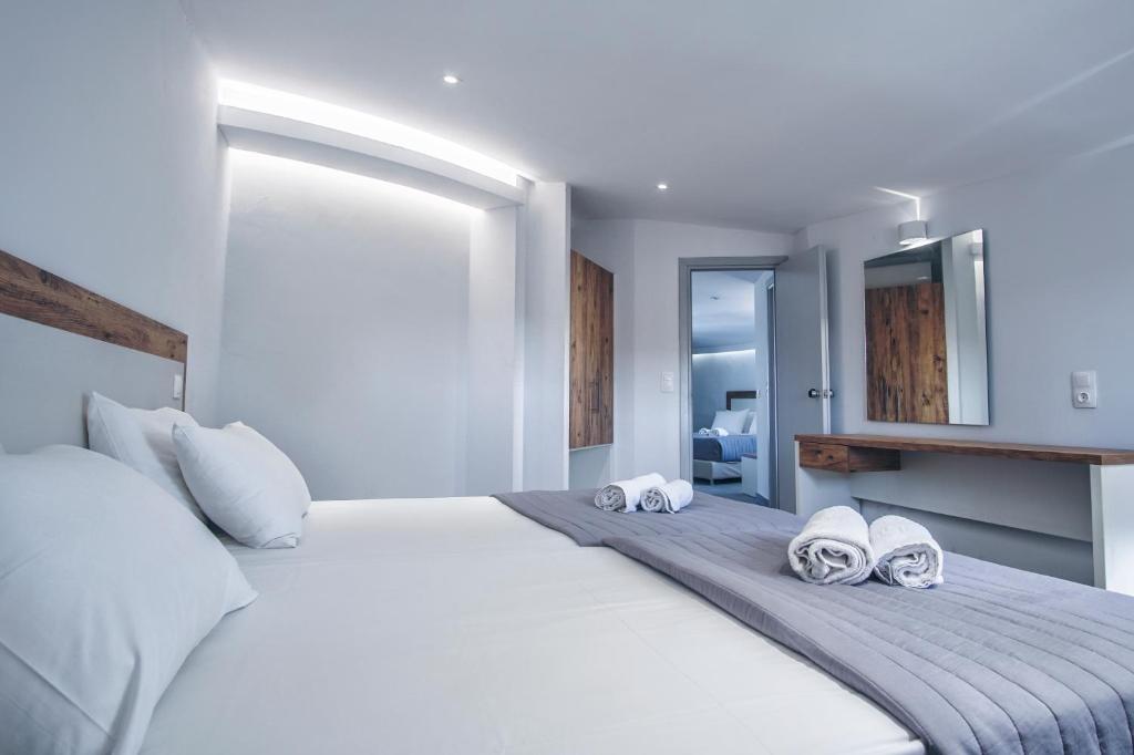 sypialnia z dużym białym łóżkiem z ręcznikami w obiekcie Island Kavos w mieście Kavos