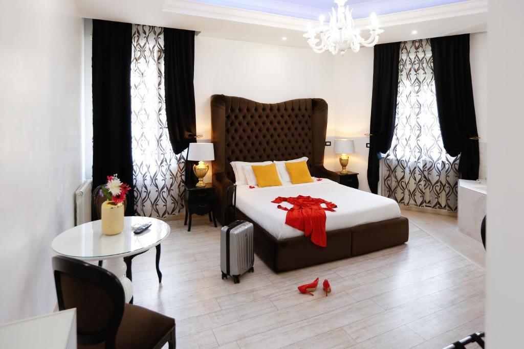 a bedroom with a large bed and a table at Escape Luxury Suite in Rome