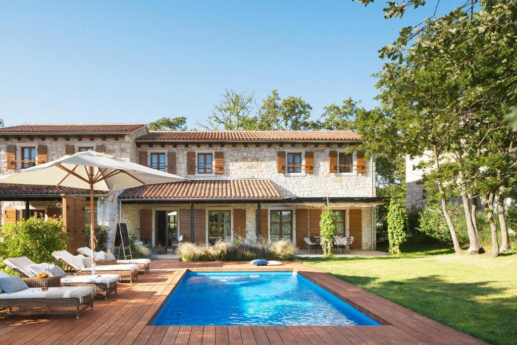 a house with a swimming pool in the yard at Meneghetti Wine Hotel and Winery - Relais & Chateaux in Bale