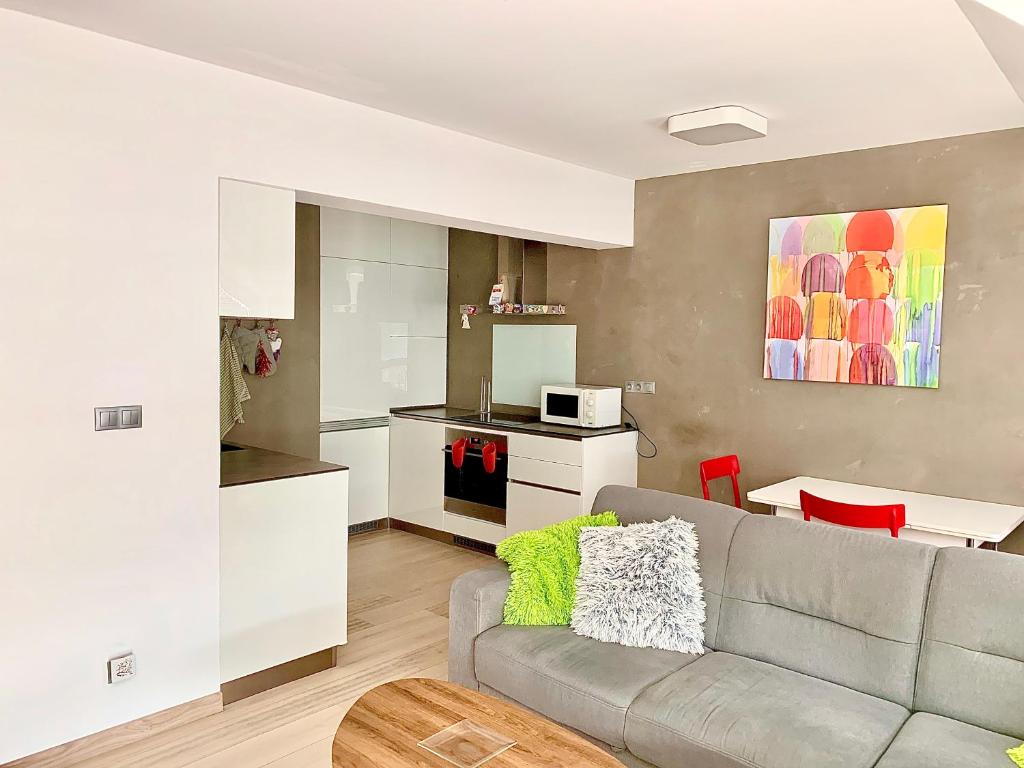 a living room with a couch and a kitchen at Luxury apartman Bojnice in Bojnice