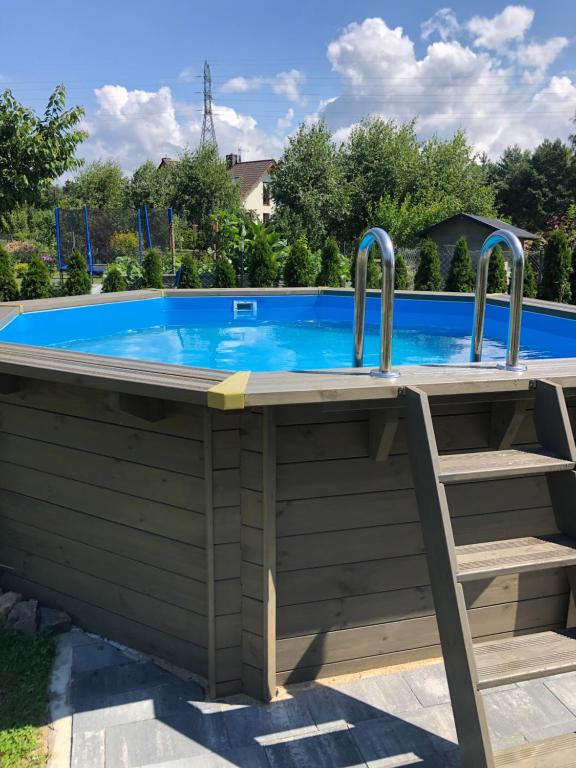 a pool deck with a hot tub and a chair at Podlasem21 in Ustka