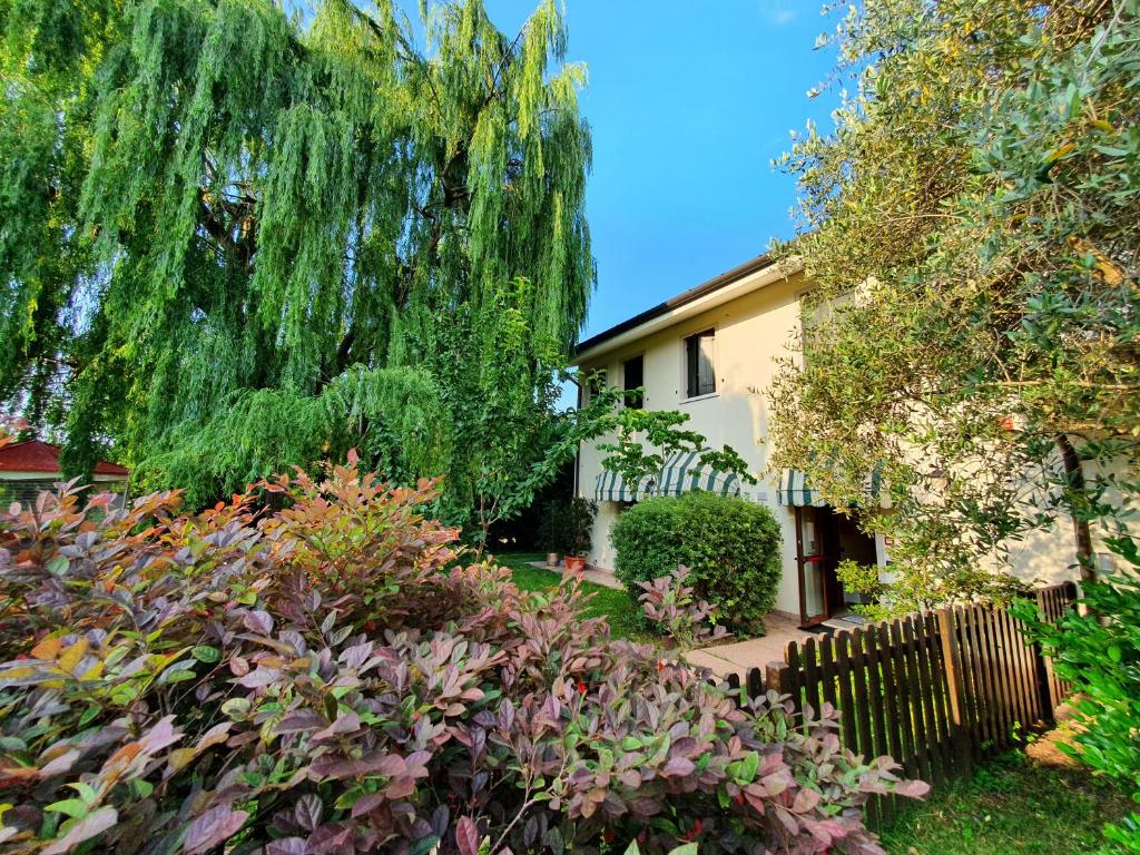 une maison avec un saule pleureur dans un jardin dans l'établissement B&B Villalta, à Trévise