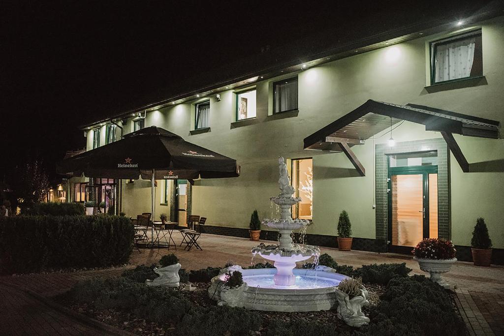 a fountain in front of a building at night at Mała Wenecja - pokoje gościnne in Nowe Worowo