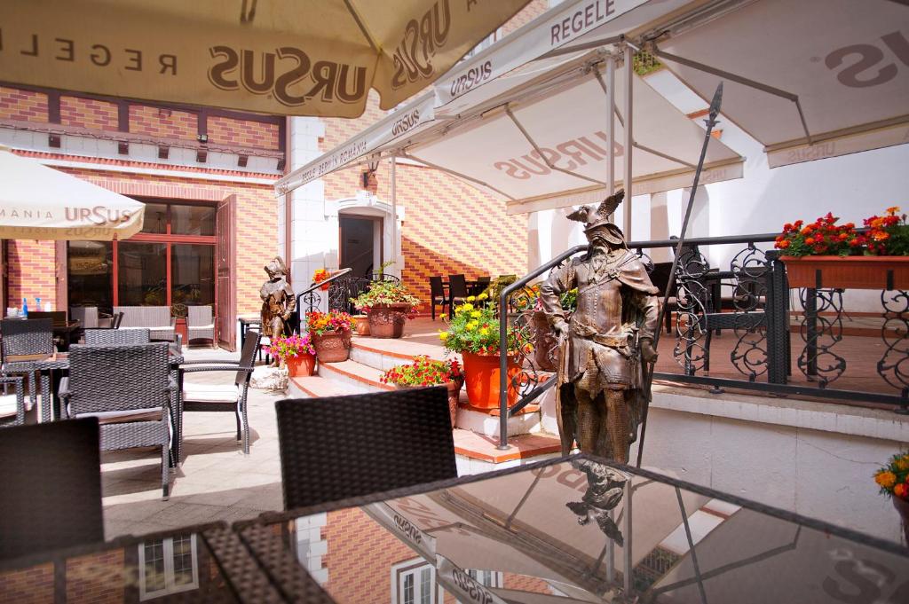 a statue of a man standing on a patio at Hotel Bastion in Sinaia