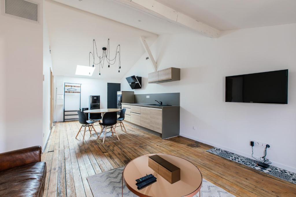 een woonkamer met een bank en een tafel bij Appartement spacieux et lumineux avec climatisation et belle hauteur sous plafond - Halle 2EME in Castillon-la-Bataille