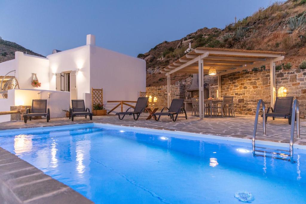 a villa with a swimming pool at night at Pleiades Villas Naxos in Agkidia