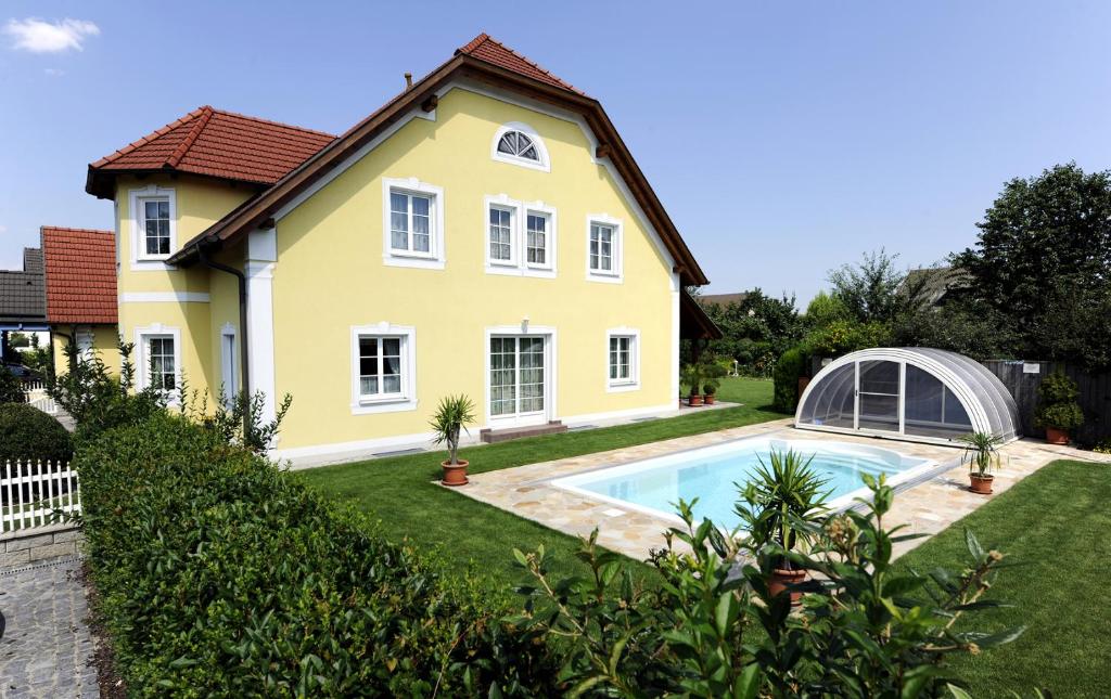 une maison avec une piscine dans la cour dans l'établissement Gästehaus Familie Trachsler, à Rohrendorf bei Krems