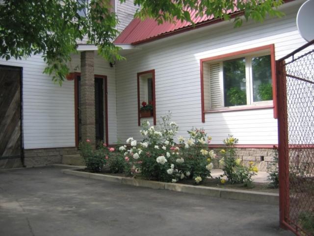 a white house with flowers in front of it at Liiva Guest Accommodation in Tartu