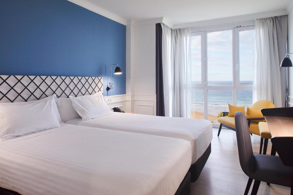 a hotel room with a large bed and a window at Silken Río Santander in Santander