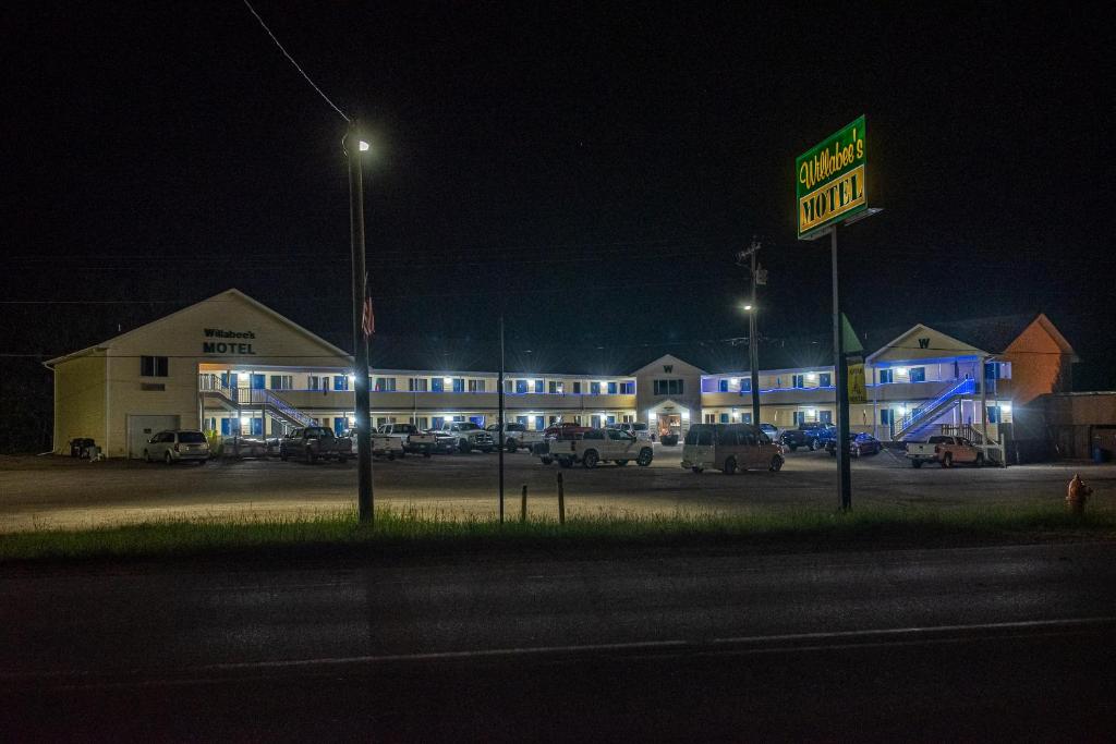 a hotel at night with a sign in front of it at Willabee's Motel in Brimley