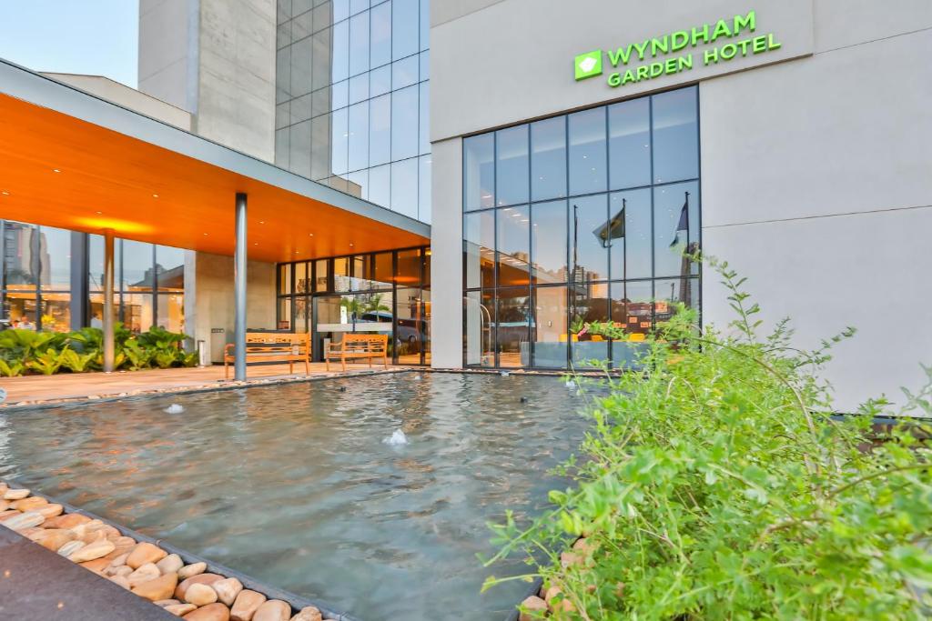 a swimming pool in front of a building at Wyndham Garden Ribeirão Preto Convention in Ribeirão Preto