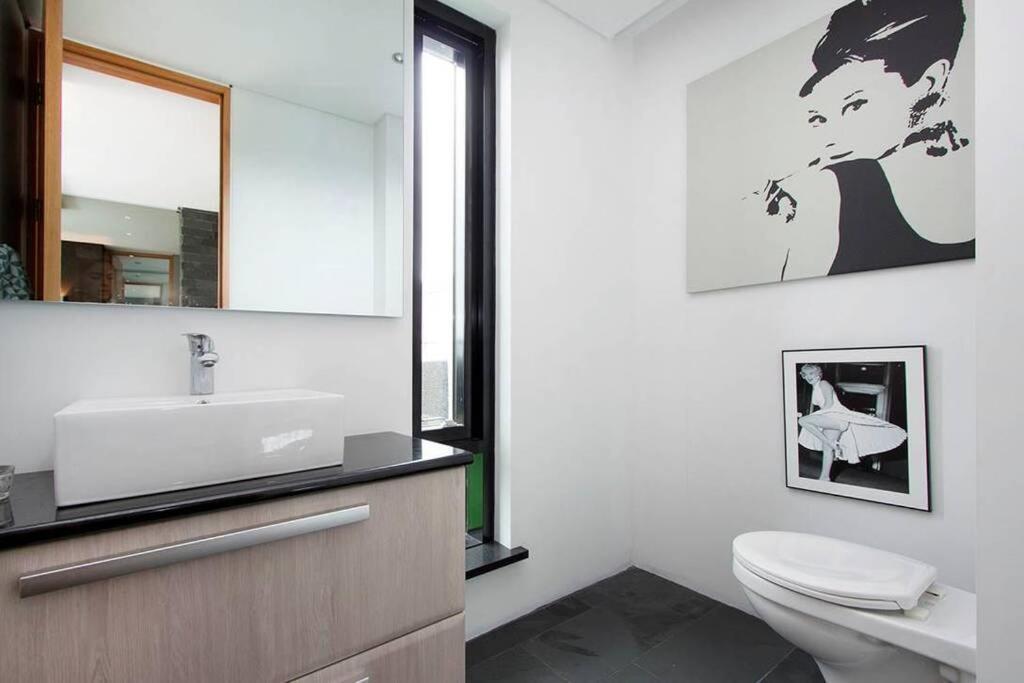 a bathroom with a sink and a toilet and a mirror at Sunny and Spacious Luxury House in Reykjavík