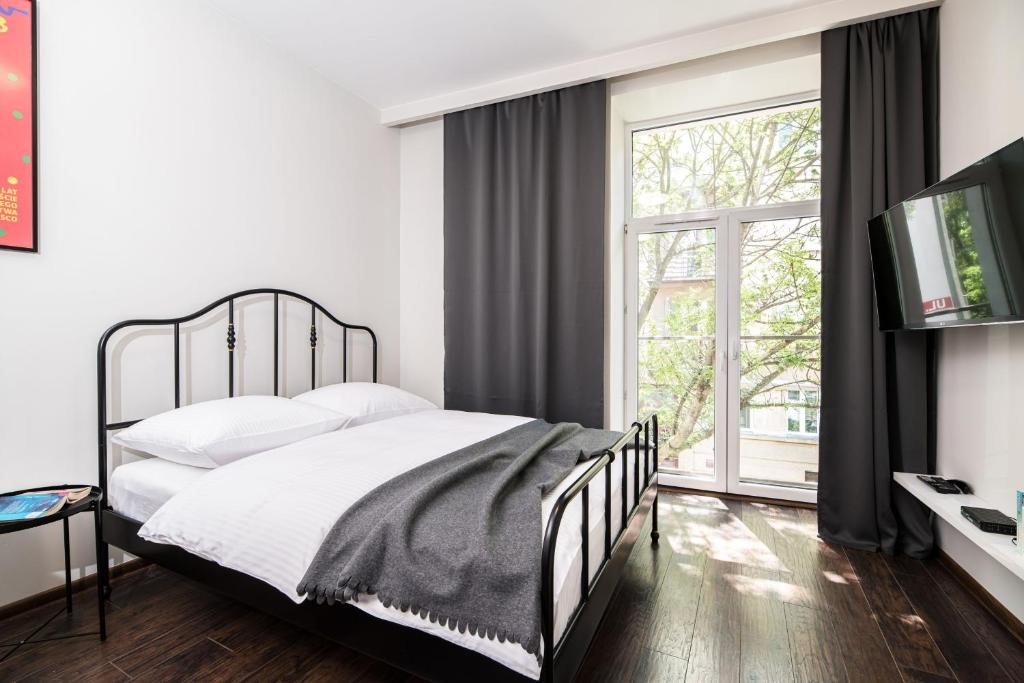 a bedroom with a bed and a large window at Native Apartments Lubelska 14 in Krakow