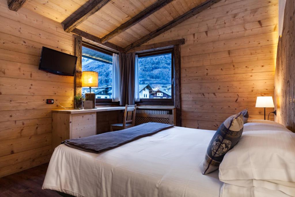 sypialnia z łóżkiem w drewnianym domku w obiekcie Hotel Nevada w mieście Bormio
