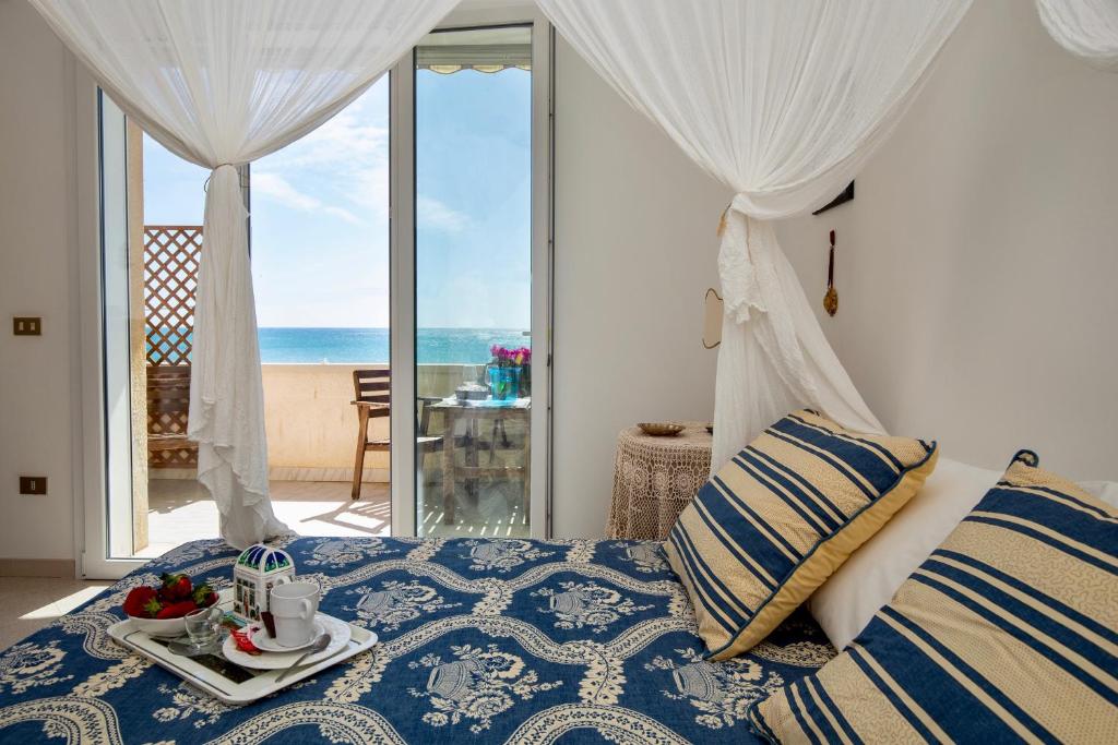 1 dormitorio con 1 cama y vistas al océano en Sunrise over the sea, en Marina di Noto