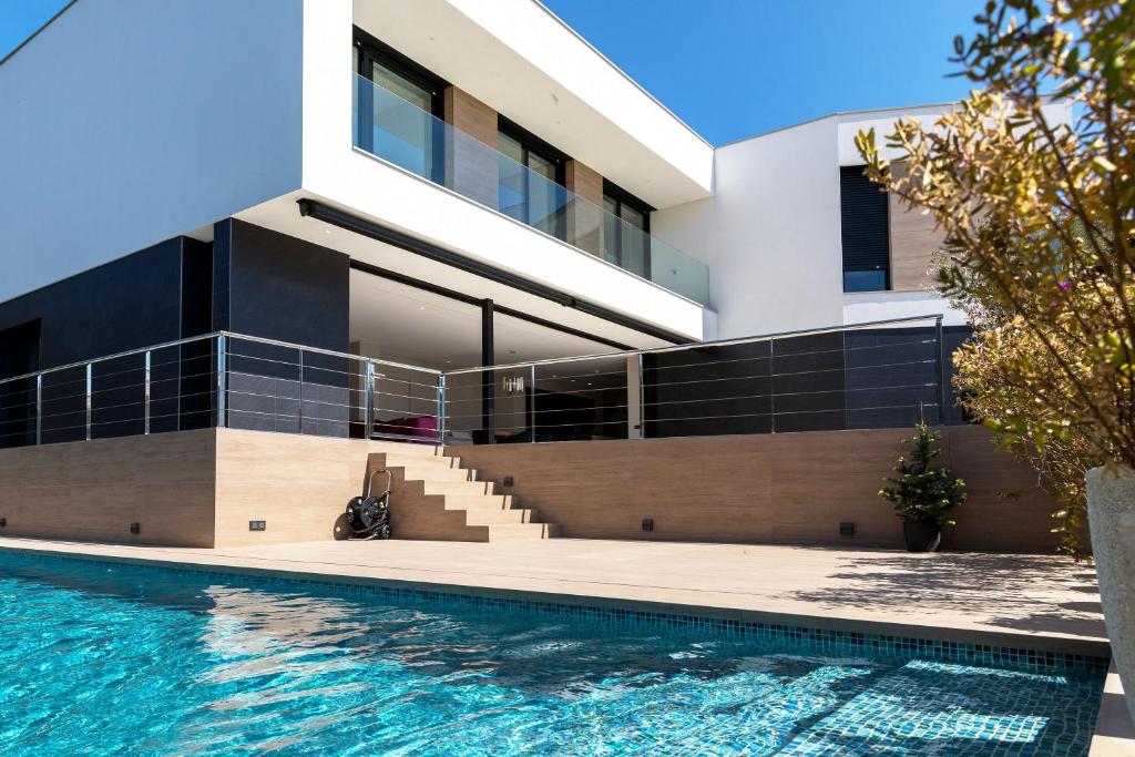 a house with a swimming pool in front of it at SPA LUXURY VILLA ***** in Platja d'Aro