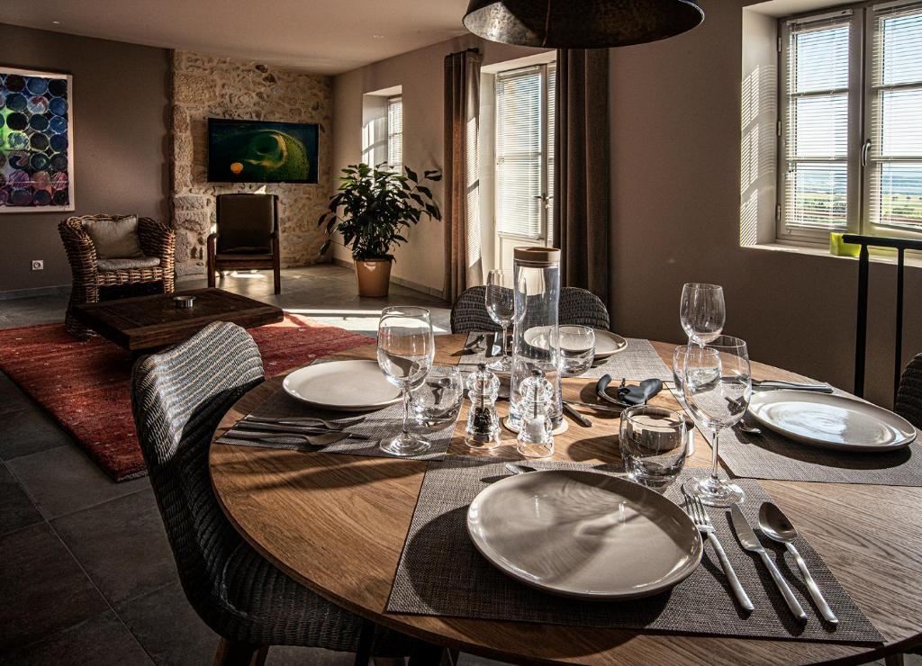 - une table en bois avec des assiettes et des verres à vin dans l'établissement The View - Gite Mont Dore, à Montpeyroux