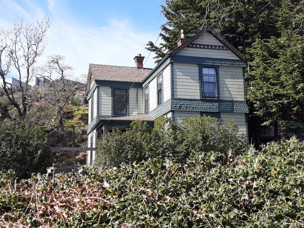 uma casa velha com um azul e branco em Sea Birds Cottage em Victoria