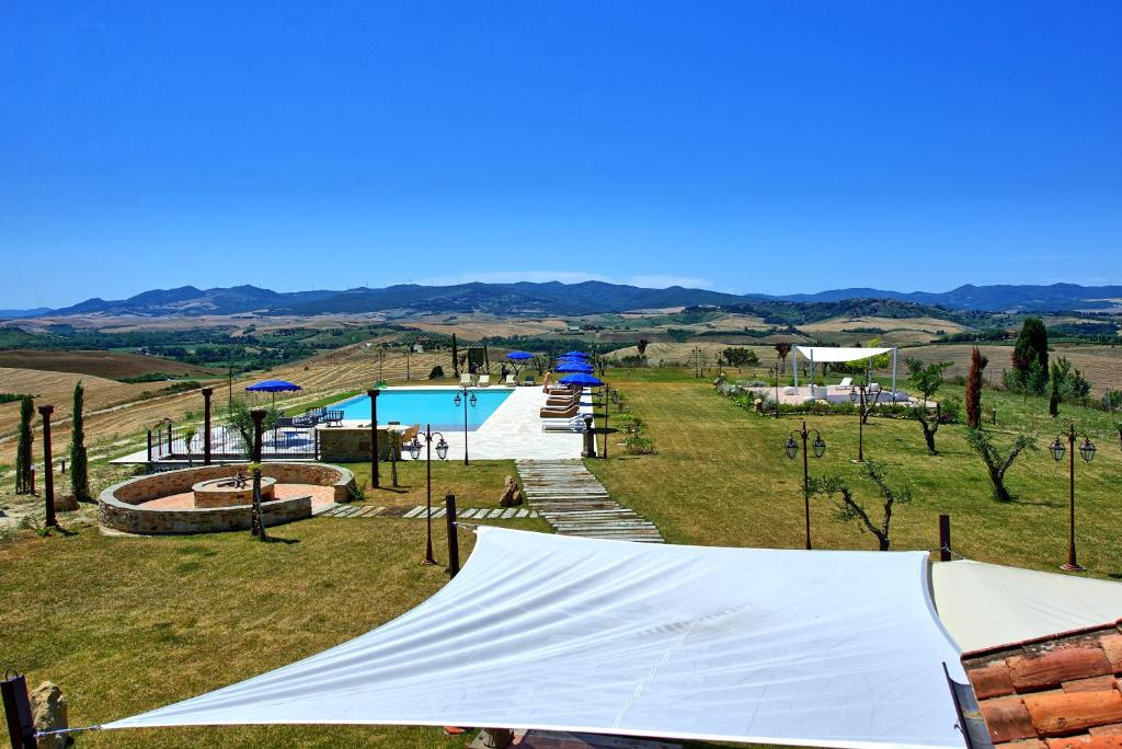 een tent in een veld met een zwembad bij Villa Massimiliano by PosarelliVillas in Volterra