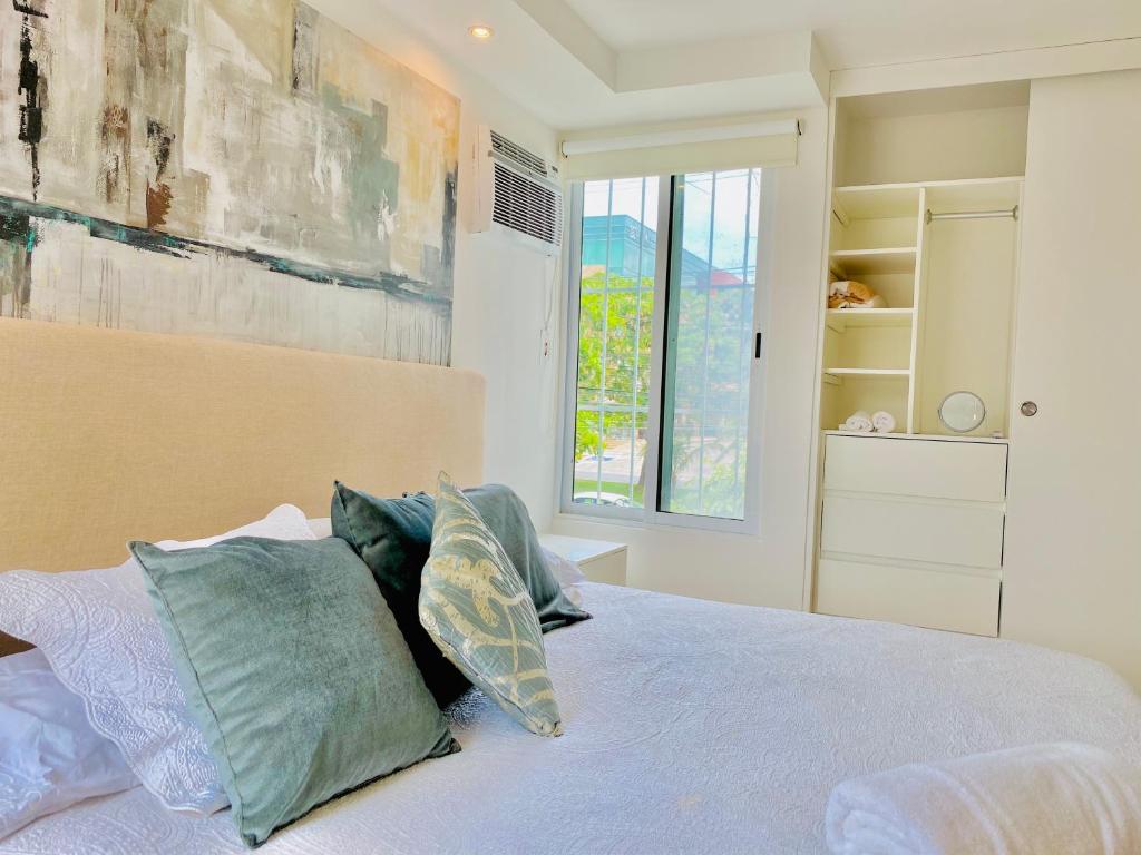 a bedroom with a bed with pillows and a window at Apartamento cálido y moderno en la entrada de la zona hotelera in Cancún