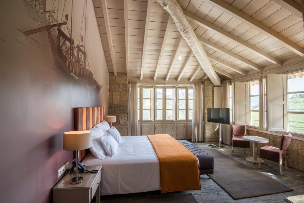 a bedroom with a bed and a flat screen tv at Vila Gale Douro Vineyards in Armamar
