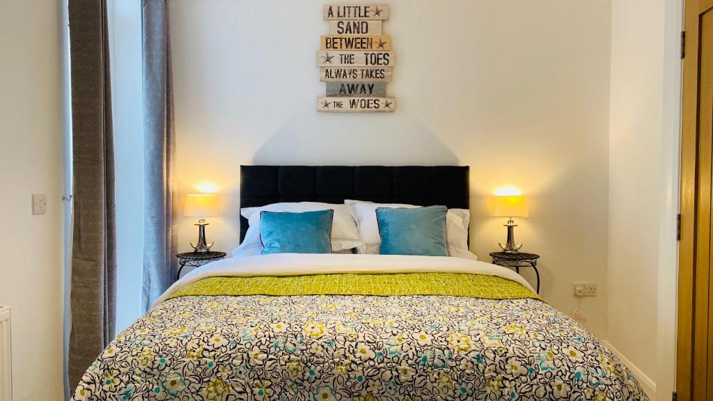 ein Schlafzimmer mit einem großen Bett mit blauen Kissen in der Unterkunft Second Nest Ramsgate in Ramsgate