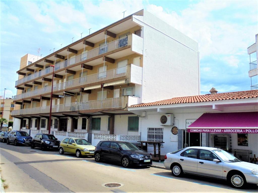 a large building with cars parked in front of it at Residencial Toboso LEK in Peniscola