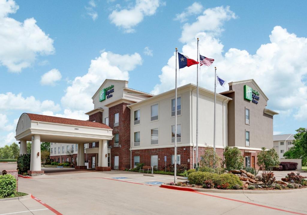 a hotel with two american flags on top of it at Holiday Inn Express Hotel & Suites Cleburne, an IHG Hotel in Cleburne