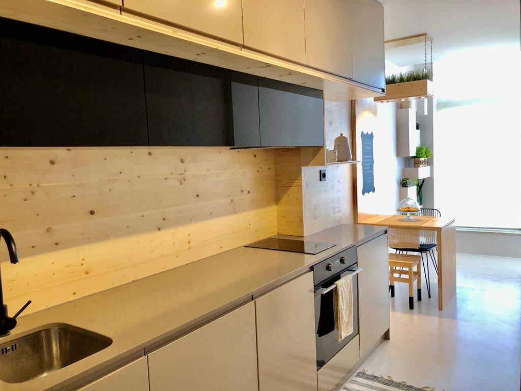 eine Küche mit weißen Schränken und einem Waschbecken in der Unterkunft Apartamento T1 no centro TÊ-U in Torres Vedras