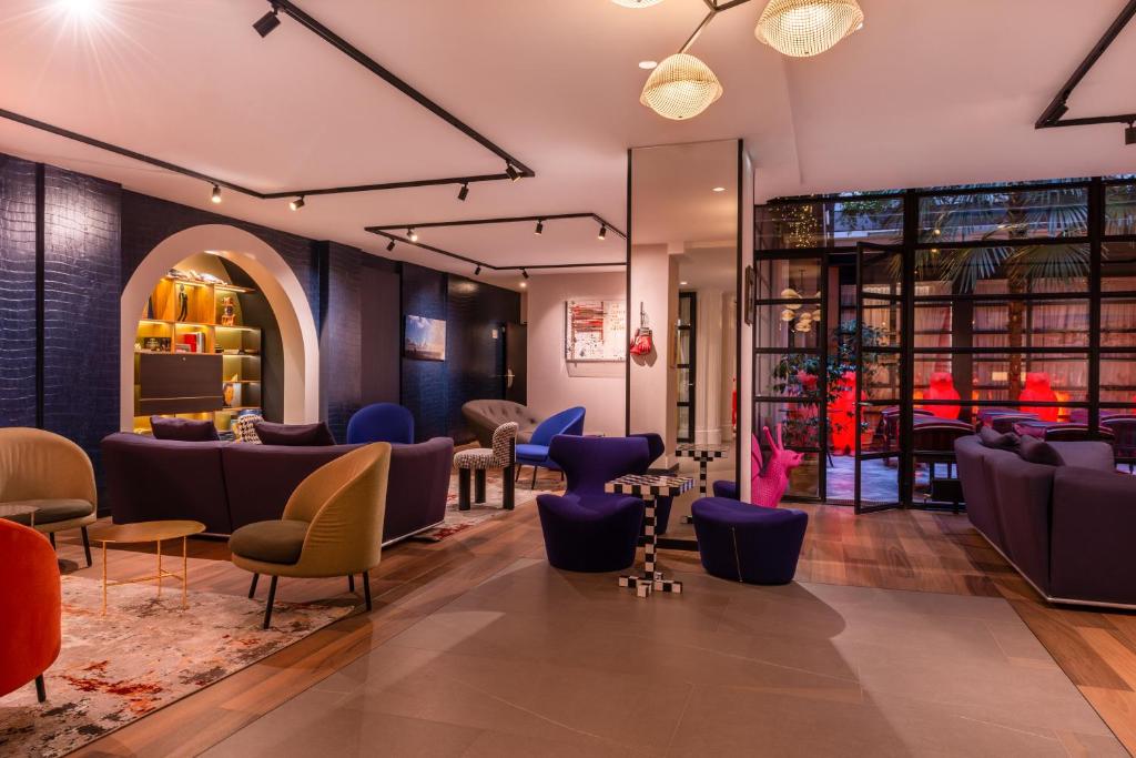 un hall d'un magasin avec des canapés et des chaises dans l'établissement Golden Tulip Opera de Noailles, à Paris