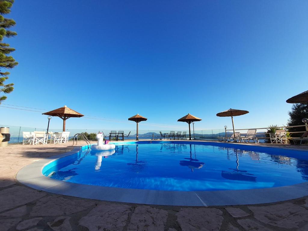 una gran piscina con sombrillas en la playa en Stefanosplace ApartHotel Sea View en Barbati