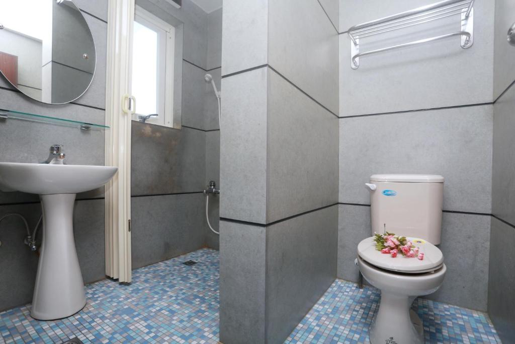 a bathroom with a toilet and a sink at Jia Ying Beach Resort B&amp;B in Toucheng